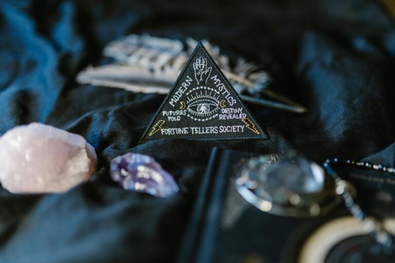 Close-up of fortune telling crystals and a mystic emblem on a dark surface.